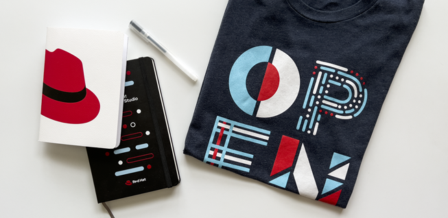 Photo of two notebooks and a t-shirt using Red Hat colors and brand elements