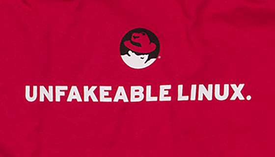 A photo of a red t-shirt featuring the Shadowman figure above the all caps text UNFAKEABLE LINUX.