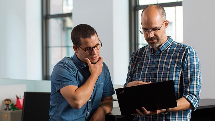 two men collaborating over a computer